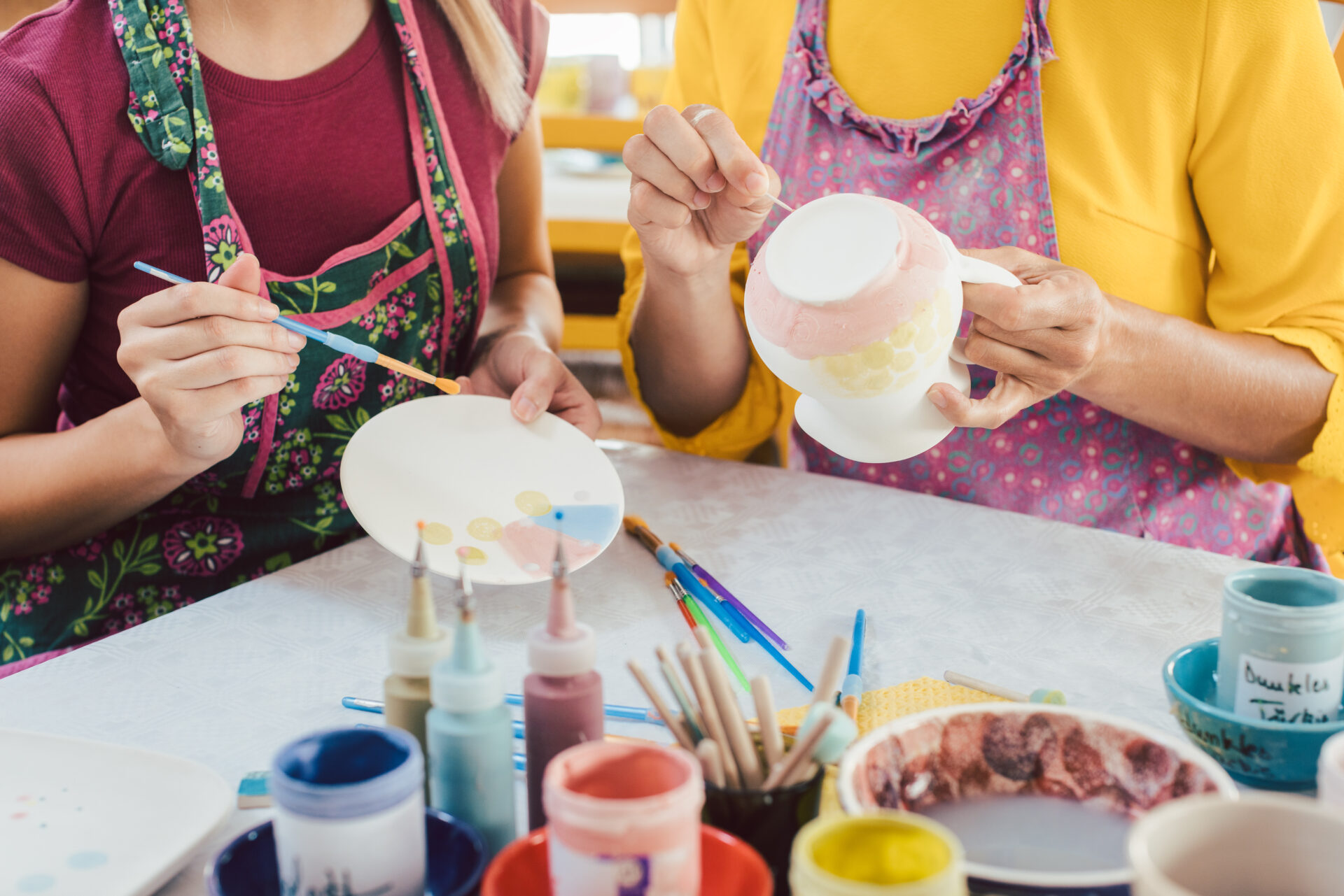 Women in DIY workshop coloring and decorating their own ceramic dishes